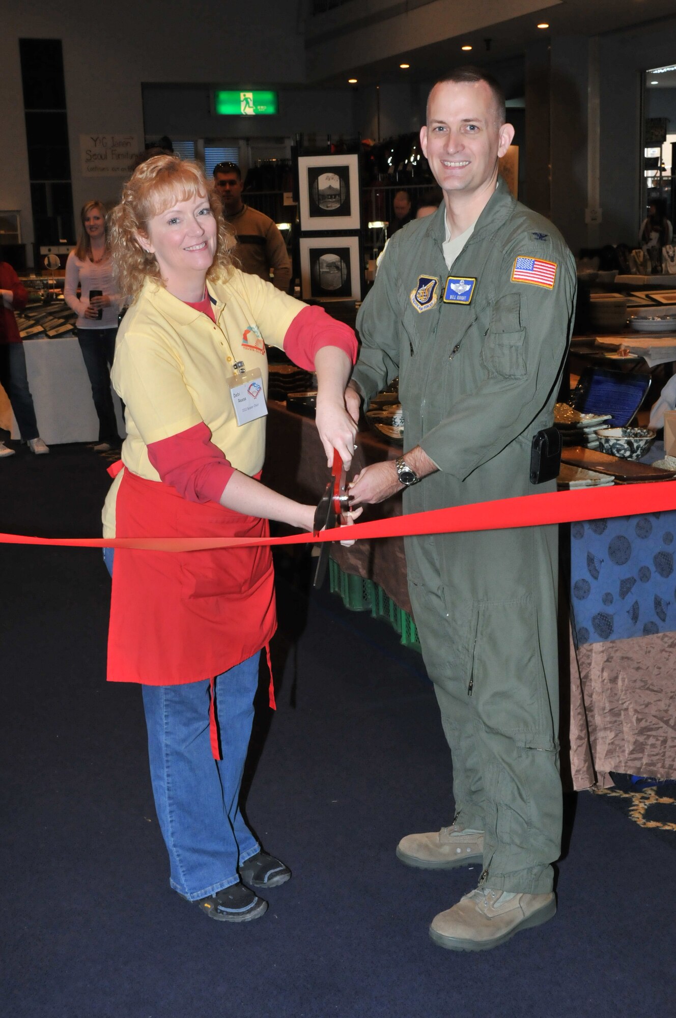 YOKOTA AIR BASE, Japan -- Col. Bill Knight, 374th Airlift Wing commander, poses with Debi Reese, bazaar chair, prior to cutting the ribbon at the Yokota Officer's Spouse's Club Asian Bazaar, March 31, 2012, at Yokota Air Base, Japan. Profits from the bazaar are given back to the Yokota community through scholarships and various community support programs. (U.S. Air Force photo/Airman 1st Class Desiree Economides)