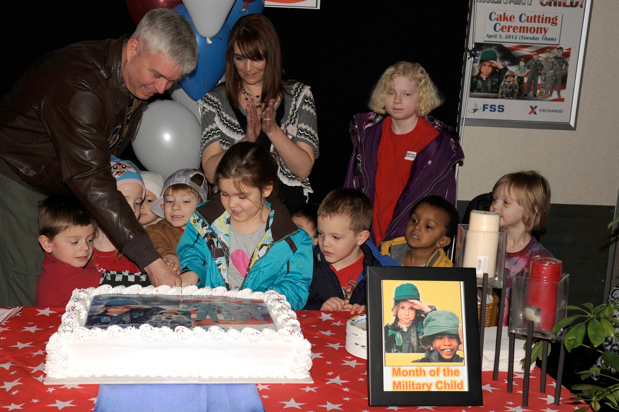 U.S. Air Force Col. Al Wimmer, 35th Fighter Wing vice commander, joins military children as they cut a cake during the Month of the Military Child kick-off ceremony at the Exchange on Misawa Air Base, Japan, April 3, 2012. In 1986 Defense Secretary Casper Weinberger designated April as the Month of the Military Child to honor military kids for their sacrifices and courage. (U.S. Air Force photo by Tech. Sgt. Marie Brown/Released)
