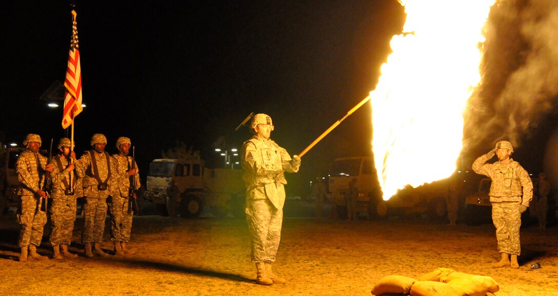 WHITE SANDS MISSILE RANGE, N.M., -- Battalion Command Sgt. Maj. Thomas Geddings holds the colors of the 2nd Engineer Battalion after Battalion Executive Officer Maj. Christian Thomas lit the flag on fire during a ceremony Nov. 30, 2011. The ceremony commemorates battalion commander Lt. Col. Alarich Zacherle’s actions Nov. 30, 1950, at Kunu-ri, during the Korean War.