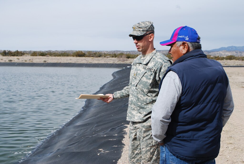 COCHITI PUEBLO, N.M., -- Officer in Charge of FEST Maj. Seth Wacker gathers information from Pete Trujillo about the drainage and sanitation of Pueblo de Cochiti’s sewage
lagoon system.
