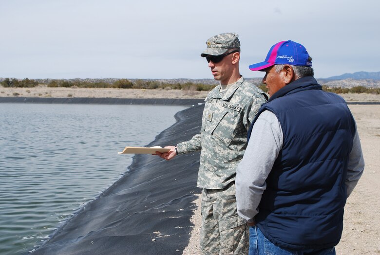 COCHITI PUEBLO, N.M., -- Officer in Charge of FEST Maj. Seth Wacker gathers information from Pete Trujillo about the drainage and sanitation of Pueblo de Cochiti’s sewage
lagoon system.
