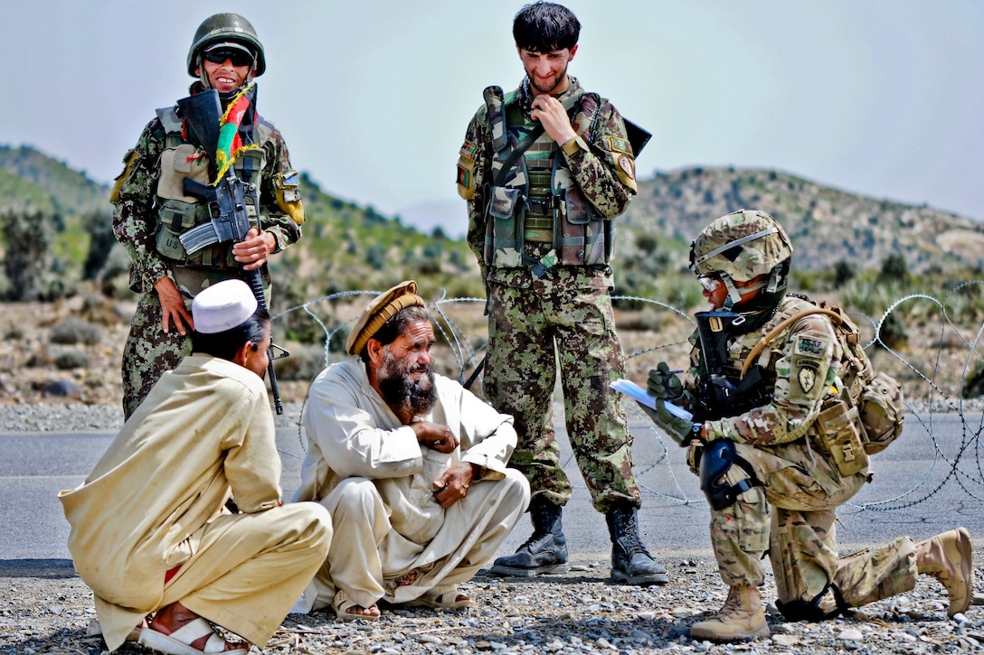 U.S. Army Spc. Shawnte Rollins, right, and Afghan soldiers collect information from motorists passing through a temporary control point at Chenigai Pass in the Bak district in Afghanistan's Khowst province, March 30, 2012. Rollins is assigned to Company D, 1st Battalion, 501st Infantry Regiment. 