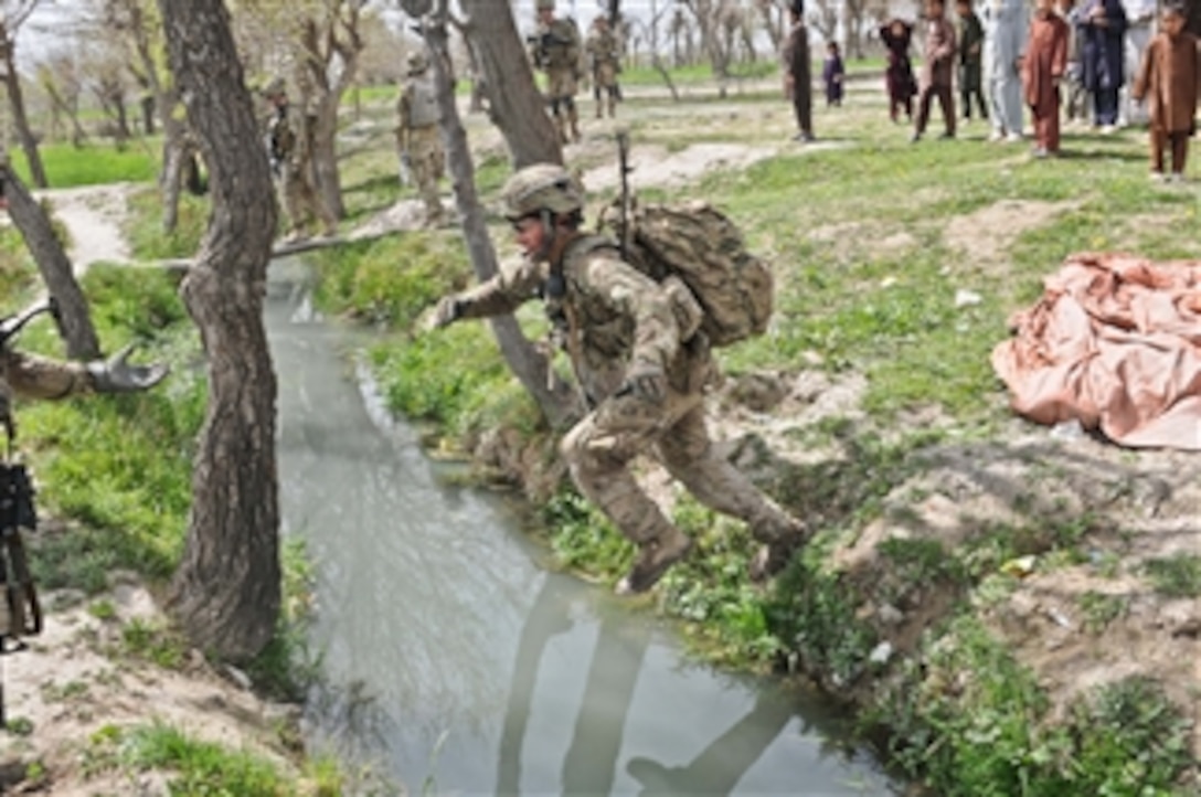 U.S. Army Staff Sgt. Andy Short, a squad leader assigned to the 3rd Platoon, Apache Company, 1st Battalion, 501st Infantry Regiment, Task Force Blue Geronimo, leaps over an irrigation canal near the village of Gorchek, Khost province, Afghanistan, during Operation Naruz, or New Year on March 30, 2012.  
