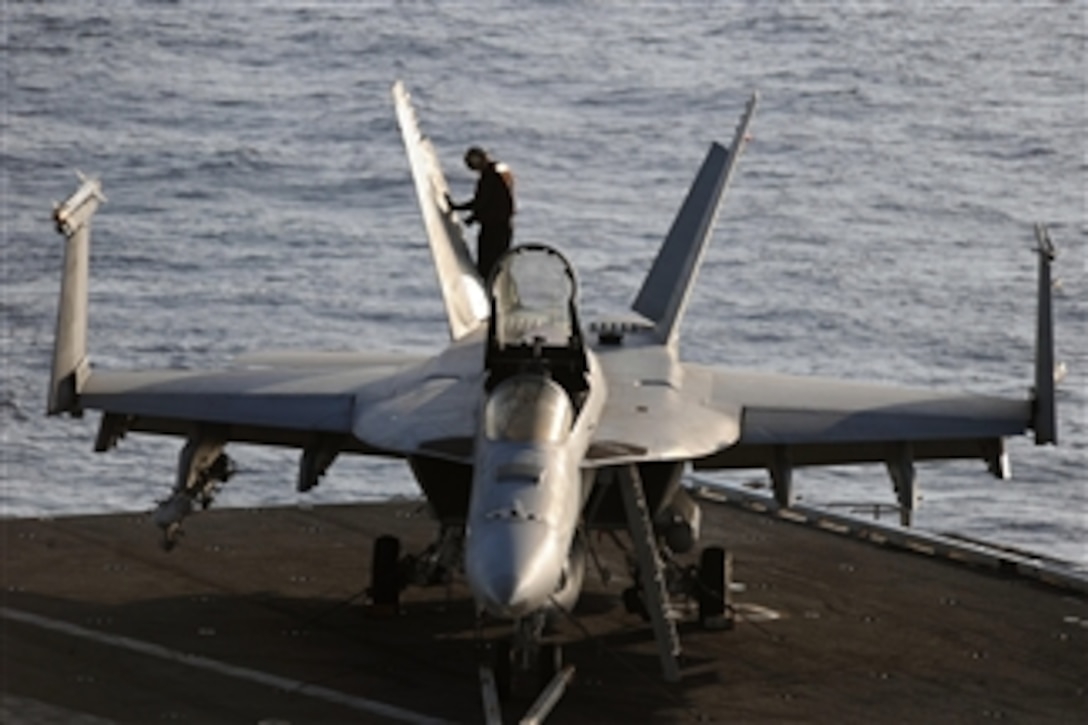 A U.S. Navy sailor aboard the aircraft carrier USS Dwight D. Eisenhower (CVN 69) performs a post-flight check on an F/A-18E Super Hornet from Strike Fighter Squadron 143 while underway in the Atlantic Ocean on March 28, 2012.  The Dwight D. Eisenhower is underway conducting training in the Atlantic Ocean.  
