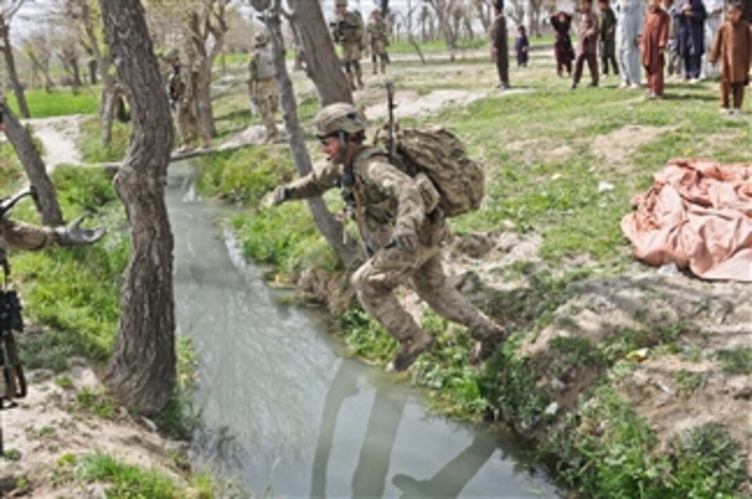 U.S. Army Staff Sgt. Andy Short, a squad leader assigned to the 3rd Platoon, Apache Company, 1st Battalion, 501st Infantry Regiment, Task Force Blue Geronimo, leaps over an irrigation canal near the village of Gorchek, Khost province, Afghanistan, during Operation Naruz, or New Year on March 30, 2012.  