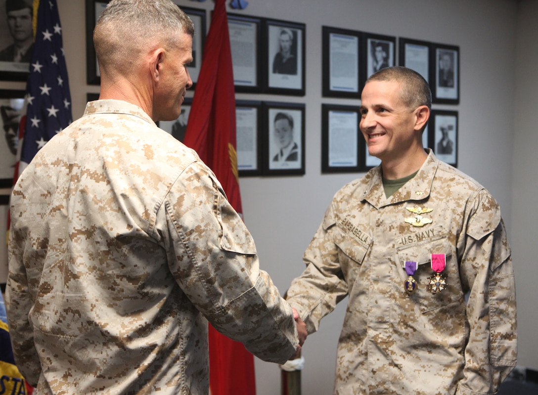 Brigadier Gen. Lewis A. Craparotta (left), who served as the commanding general of 2nd Marine Division (Forward) in Afghanistan, shakes hands with Cmdr. Sean Barbabella, who deployed with the division as the division surgeon.  Barbabella received a Purple Heart and the Legion of Merit, one of the military’s highest decorations, during a ceremony April 5.