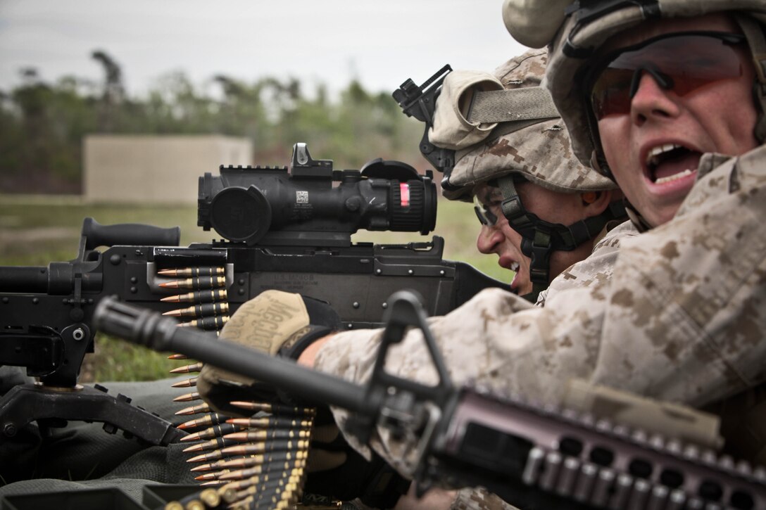 Lance Cpl. Adam Wolfel (right) of St. Marys, Pa., yells commands during a live-fire exercise recently. The machine gun team leader with Company F, 2nd Battalion, 8th Marine Regiment, 2nd Marine Division, led his team through the burning fields and smoke-filled air to the end of the range.