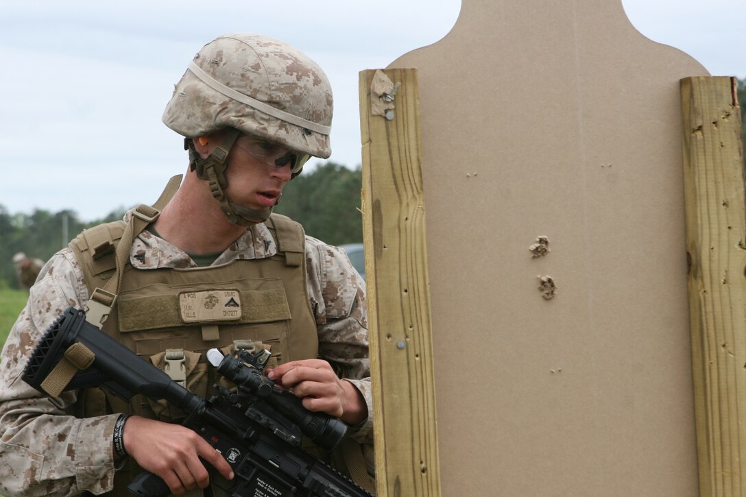 Lance Cpl. Michael Mills, a scout with 2nd Light Armored Reconnaissance Battalion, 2nd Marine Division, checks two sets of grouped bullet holes as he adjusts the rifle optic on his M27 Infantry Automatic Rifle for accuracy.  The Wytheville, Va., native served a combat tour to Afghanistan with the M-249 Squad Automatic Weapon but said he immediately preferred the M27 IAR after firing it for the first time.