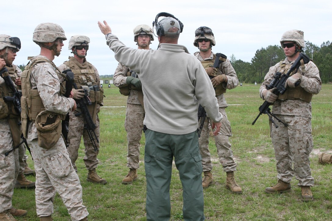 Marines with 2nd Light Armored Reconnaissance Battalion, 2nd Marine Division listen as one of the range personnel gives them some pointers about firing the Infantry Automatic Rifle.  The Marines are training with the weapon meant to replace the M249 Squad Automatic Weapon in the unit’s upcoming deployment.