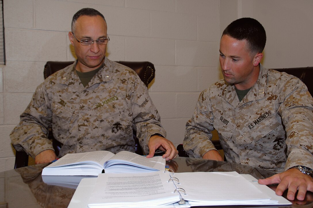 Lt. Col. Alex Ray, left, Staff Judge Advocate, and Capt. Tyler Gludt, deputy staff judge advocate, MCLB Albany, review regulations concerning ethics rules regarding gifts to Marines and requests for support.