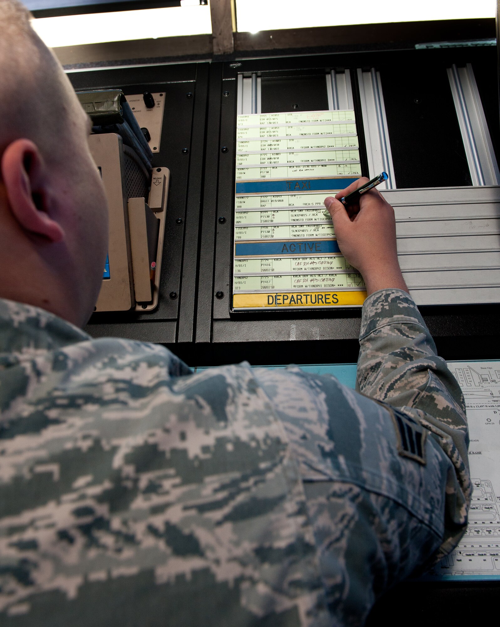 Senior Airman Mark Ensign, 28th Operations Support Squadron air traffic control journeyman, updates flight progress data in the ATC tower on Ellsworth Air Force Base, S.D. April 3, 2012. Flight data must be accurate and current to efficiently track and manage all aircraft in Ellsworth’s area of responsibility. (U.S. Air Force photo by Airman 1st Class Kate Thornton/Released)