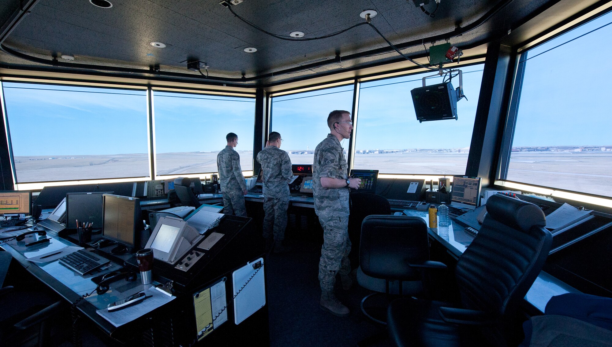 (From left) Airman 1st Class Austin Layton, Airman 1st Class Shane Kobzina, and Senior Airman William Olson, 28th Operations Support Squadron air traffic controllers, visually scan the airfield for safety risks in the ATC tower on Ellsworth Air Force Base, S.D. April 3, 2012. Scanning the runway helps prevent vehicles, people and any animals from jeopardizing airfield safety. (U.S. Air Force photo by Airman 1st Class Kate Thornton/Released)