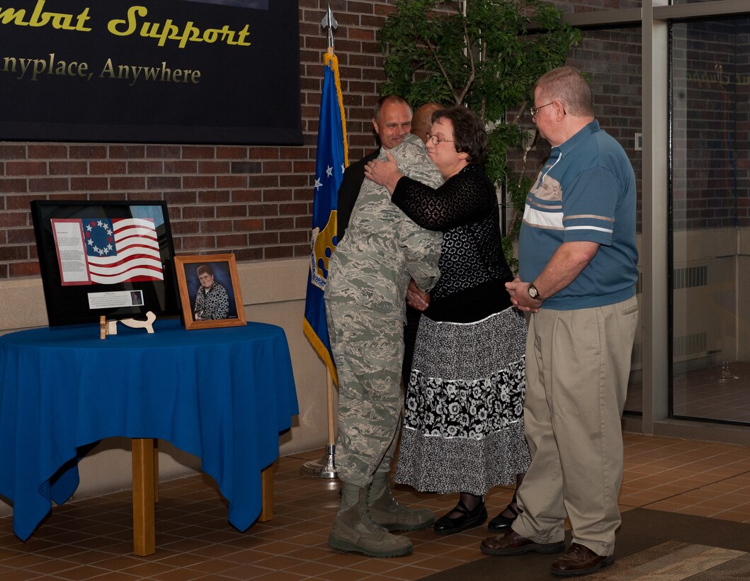 Col. Trent Edwards, 28th Mission Support Group commander, hugs Bonnie Avery, mother of Jennifer Avery, during a presentation of Jennifer’s artwork at Ellsworth Air Force Base, S.D., April 4, 2012. Jennifer loved history, and like most of us she was emotionally affected by all of the events of 9/11 and felt that it was her love of history that inspired her to create a work of art dedicated to those who serve their country. (U.S. Air Force photo by Airman 1st Class Alystria Maurer/Released)