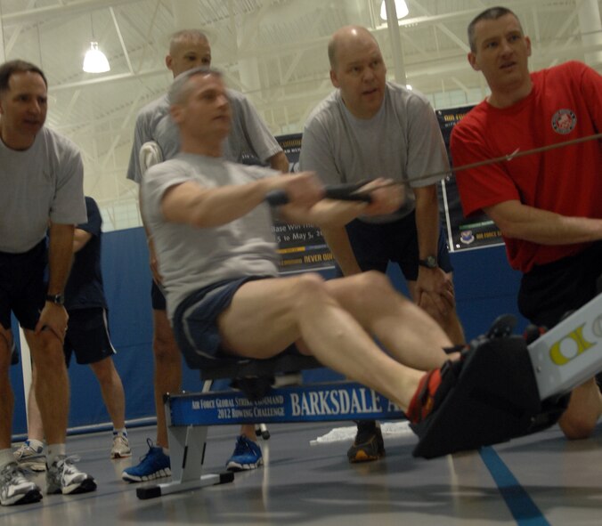 Dan Beery, Olympic Gold-World Champion, far right, watch as Airmen participate in the Air Force Global Strike Command American 300 Never Quit Series Rowing Challenge at the fitness center on Barksdale Air Force Base, La. April 5. The one month challenge is to see which AFGSC base can row the most meters. The base that rows the furthest will win $50,000. (U.S. Air Force photo/Airman 1st Class Joseph A. Pagán Jr.)(RELEASED)