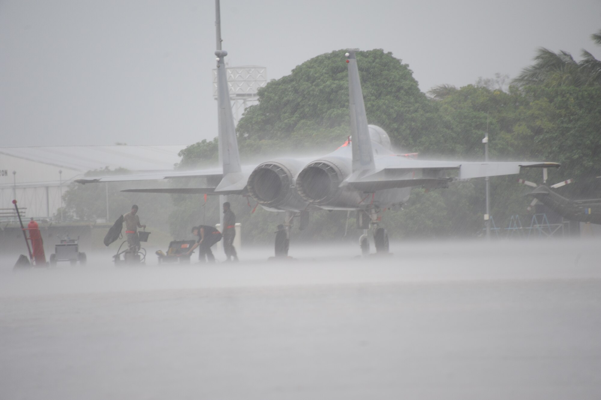 Airmen from the 67th Aircraft Maintenance Unit based at Kadena Air Base, Japan, take shelter under the wing of an F-15C during a rain shower at Cope Taufan 2012 at TUDM Butterworth Apr. 3, 2012. Cope Taufan, the biennial live-flying exercise between the U.S. Air Force and RMAF, includes dissimilar basic fighter maneuvers and dissimilar air combat tactics training.  (U.S. Air Force photo/Master Sgt. Matt Summers/released)