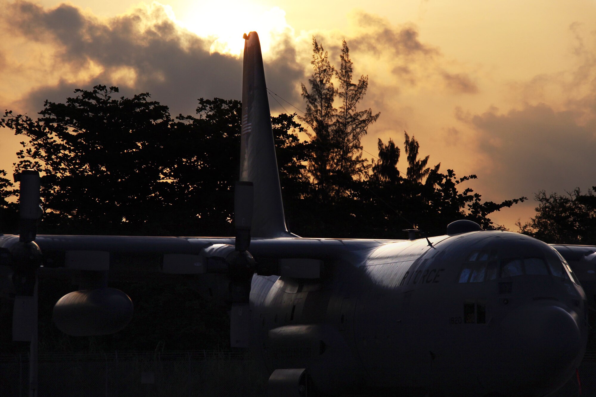 The sun rises over a Puerto Rico Air National Guard C-130 while 911th Airlift Wing crews arrive on base to begin preparations for an early morning mission on April 4, 2012.  Unit members are currently supporting Air Expeditionary Force 'Coronet Oak' operations based out of Muniz Air National Guard Base, Puerto Rico. (U.S. Air Force photo by Capt. Shawn M. Walleck/Released) 