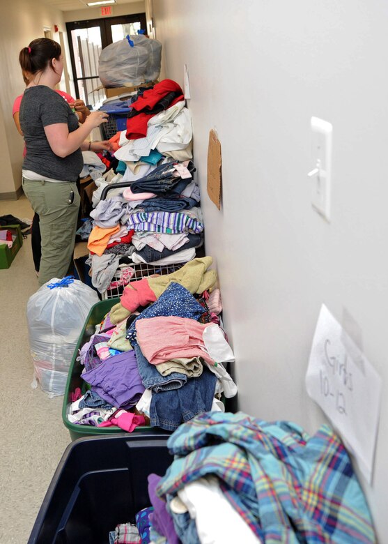 Volunteers sort through piles of clothes March 30 that were donated to the Andrews Attic in support of families effected by a base housing fire. (U.S. Air Force photo/Senior Airman Laura Turner)