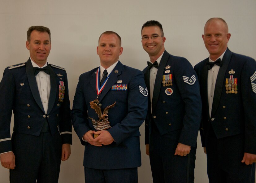 U.S. Air Force Staff Sgt. Brandon Smith, 23d Logistics Readiness Squadron, receives a  Distinguished Graduate award during an Airman Leadership School graduation April 3, 2012, at Moody Air Force Base, Ga. This award is presented to the student whose academic performance and leadership skills placed him in the top ten percent of the class. (U.S. Air Force photo by Senior Airman Eileen Meier/Released)