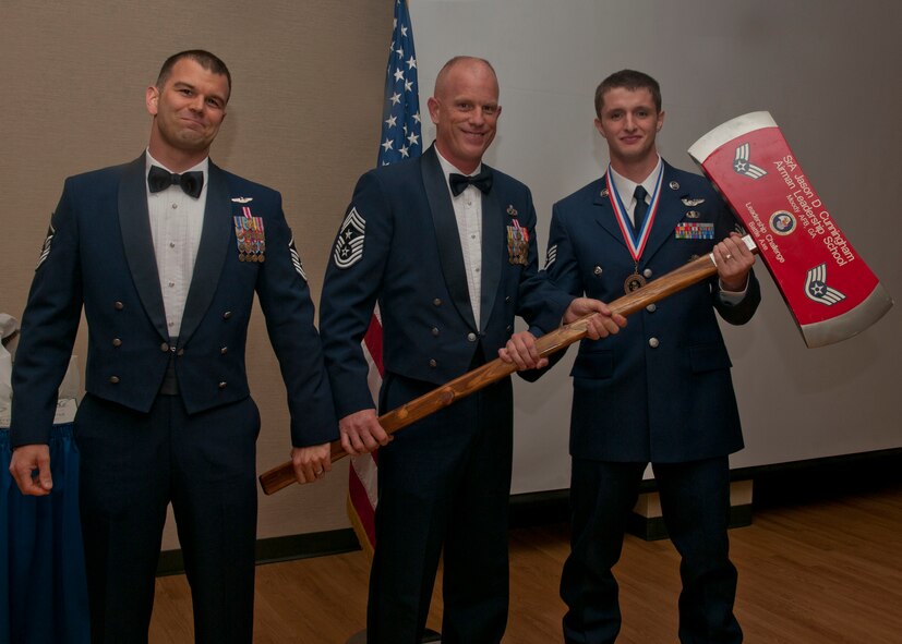 U.S. Air Force Staff Sgt. Matthew Blankenship, 38th Rescue Squadron, presents the Senior Airman D. Cunningham Battle Axe to Master Sgt. John Vena, 823d Base Defense Squadron first sergeant, and Chief Master Sgt. Frank Batten, 23d Wing command chief, during an Airman Leadership School graduation April 3, 2012, at Moody Air Force Base, Ga. The battle axe is a trophy awarded to the winner of a sports game between the Top Three senior enlisted organization and ALS students. (U.S. Air Force photo by Senior Airman Eileen Meier/Released) 