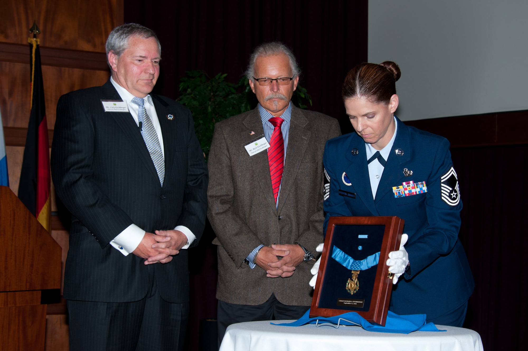 Senior Master Sgt. Karen Steffes-Graves presents the Medal of Honor awarded to Chief Master Sgt. Richard L. Etchberger to his sons Cory, left, and Rich, center, during the ceremony marking the medal's donation to the Enlisted Heritage Research Institute at Gunter Annex, Ala., March 26, 2012. (U.S. Air Force photo/Melanie Rodgers Cox)