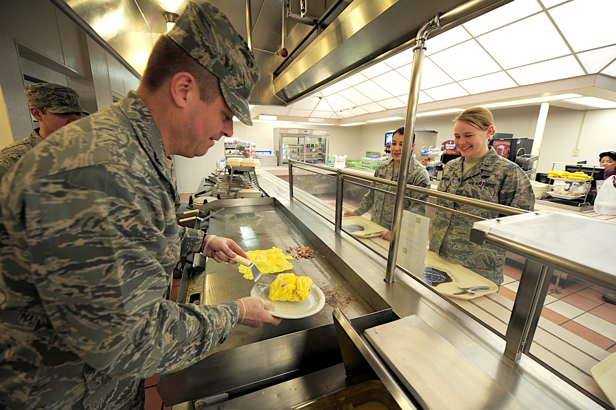 Col. Mike Hill, 92nd Mission Support Group commander, serves food to members of Team Fairchild during the breakfast rush in the Warrior Dining Facility at Fairchild Air Force Base, Wash., March 23, 2012. The colonel will periodically participate in the work his Airmen perform to better understand the effort put into the mission. (U.S. Air Force photo by Airman 1st Class Taylor Curry/Released)