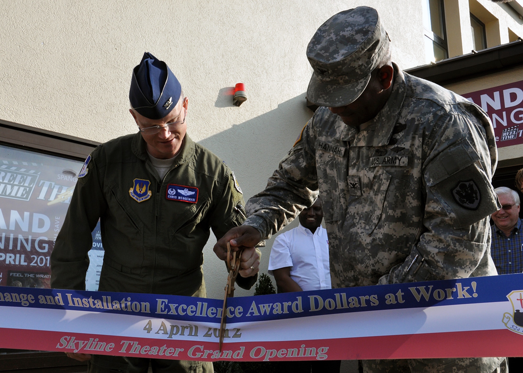 SPANGDAHLEM AIR BASE, Germany – U.S. Air Force Col. Chris Weggeman, 52nd Fighter Wing commander, and U.S. Army Col. Fred Hannah, Exchange Europe commander, cut a ribbon during a ribbon-cutting ceremony at the Spangdahlem Skyline Theater grand reopening here April 4. The two organizations jointly renovated and upgraded the facility through shared financial contributions. The 52nd FW spent $575,850 of the Commander in Chief’s 2011Installation Excellence award money for building renovations, and the Exchange spent $350,000 for system upgrades. This is the first Exchange theater in the world to have 3-D capabilities and full digital audio and video. (U.S. Air Force photo by Staff Sgt. Daryl Knee/Released)