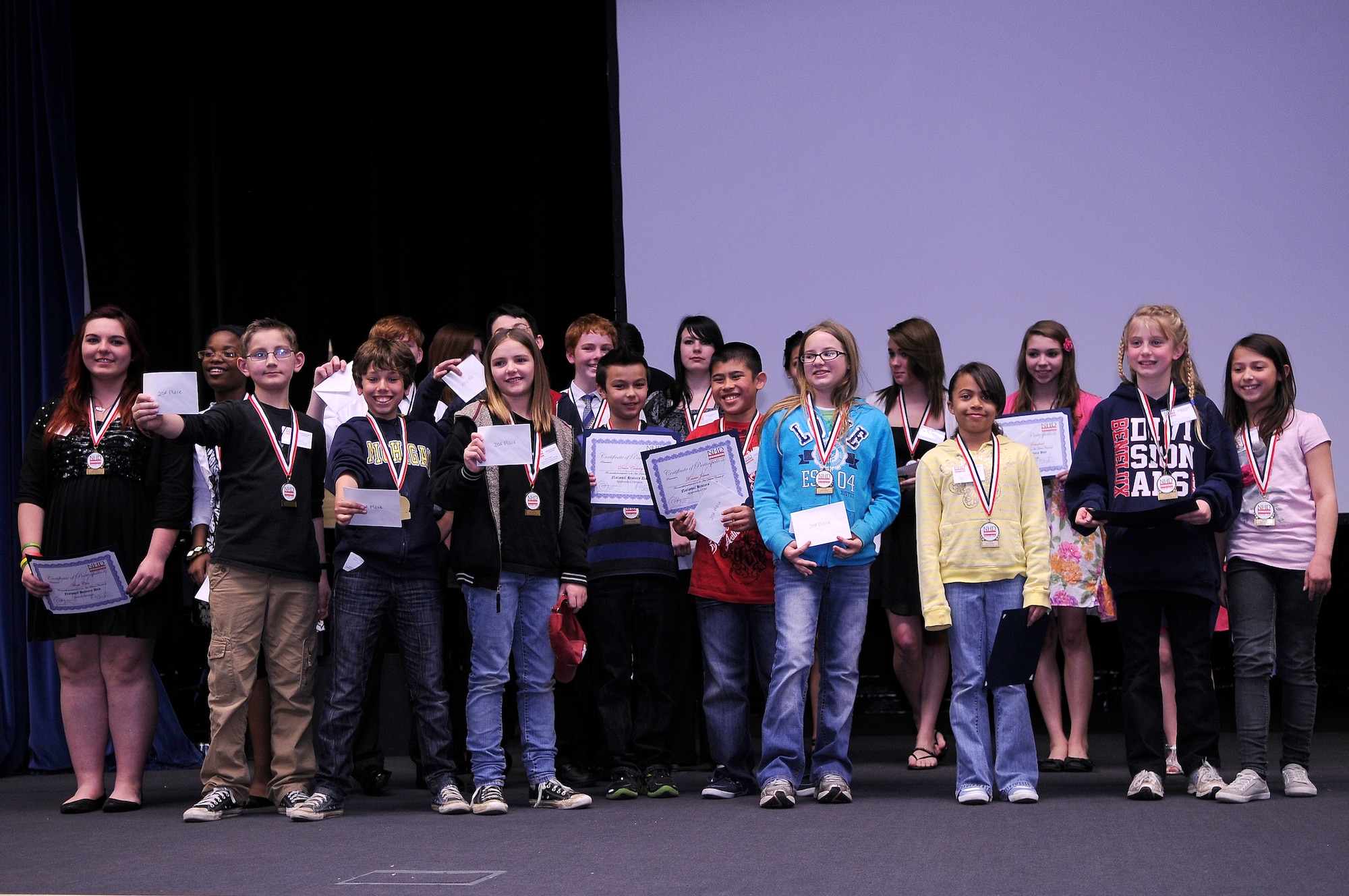 ROYAL AIR FORCE LAKENHEATH, England -- Department of Defense Dependents Schools Europe students show off their awards during the National History Day contest at the Lakenheath High School auditorium April 3, 2012.  National History Day is a national academic program for students in grades 6 through 12. The first and second place winners were awarded with gift certificates, a check and a medal. (U.S. Air Force photo by Staff Sgt. Connor Estes) 
