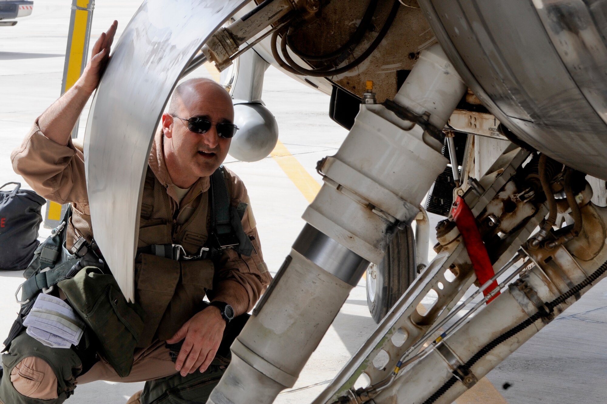 SOUTHWEST ASIA -- Col. Rodney Petithomme, 332nd Expeditionary Operations Group commander, inspects the under belly of an F-16 Fighting Falcon during a preflight inspection here April, 3 2012. Pilots perform an eyes-on inspection prior to every flight. Petithomme is deployed from Osan Air Base, Korea, and is a native of Clovis, Calif.  (U.S. Air Force photo by Staff Sgt. Joshua J. Garcia)