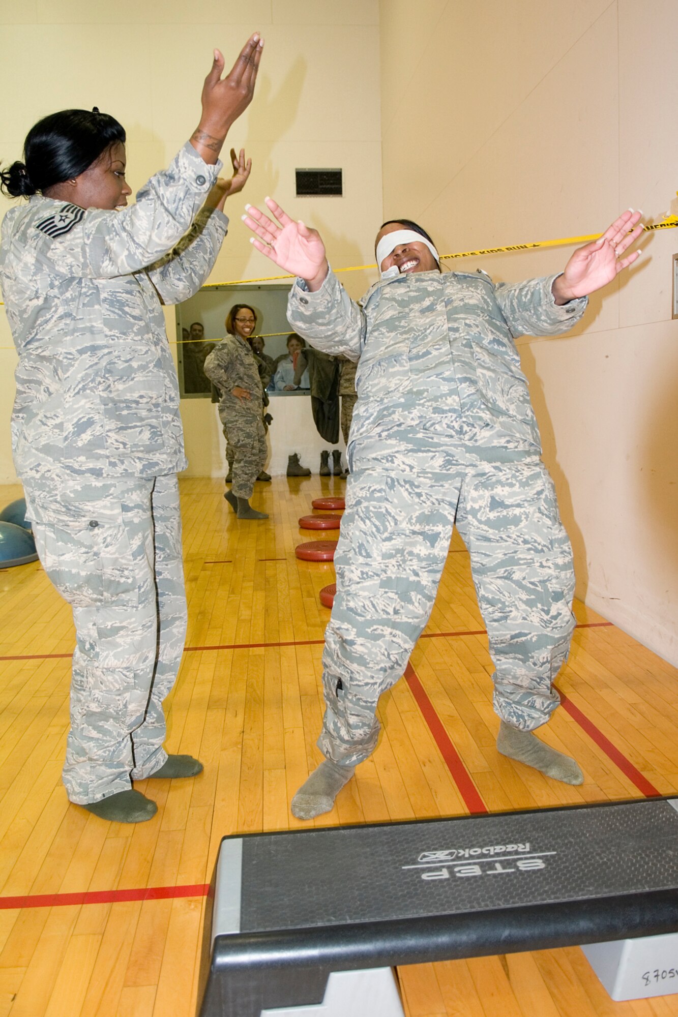 Tech. Sgt. Danielle Taylor, left, uses dance moves as she guides Senior Airman Amanda White through an obstacle course set up at the fitness center. Both are members of the 434th Force Support Squadron. (U.S. Air Force photo/Tech. Sgt. Douglas Hays)