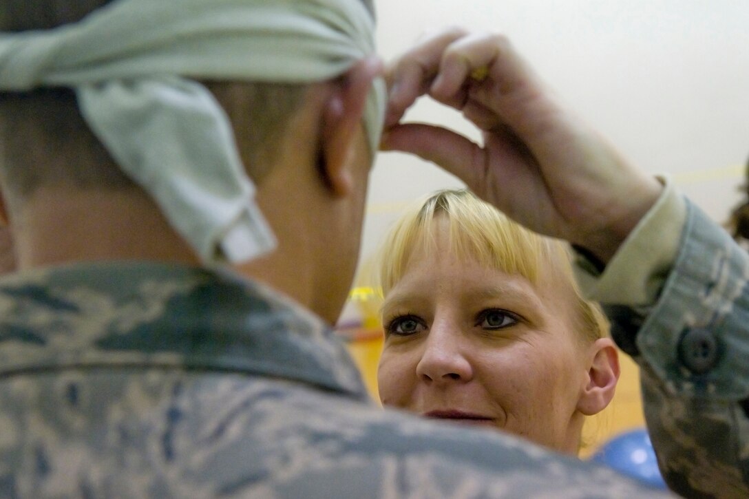GRISSOM AIR RESERVE BASE, Ind. -- Master Sgt. Cindy Webb places a blindfold on Chief Master Sgt. William Somers, both members of the 434th Force Support Squadron, as she gets ready to guide him through an obstacle course as part of a Wingman Day exercise held March. 4. (U.S. Air Force photo/Tech. Sgt. Douglas Hays)