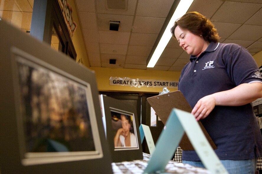 HANSCOM AIR FORCE BASE, Mass. -- Julie Frederick, 66th Force Support Squadron youth programs director, sets up a Boys and Girls Club of America Image Makers photography exhibit at the Youth Center March 28.  Youth Center members have been learning about photography concepts.  The purpose of this contest is to motivate members to hone their photography skills, encourage them to participate in photography classes and other arts-related activities and to showcase the youth art program.  (U.S. Air Force photo by Mark Wyatt)