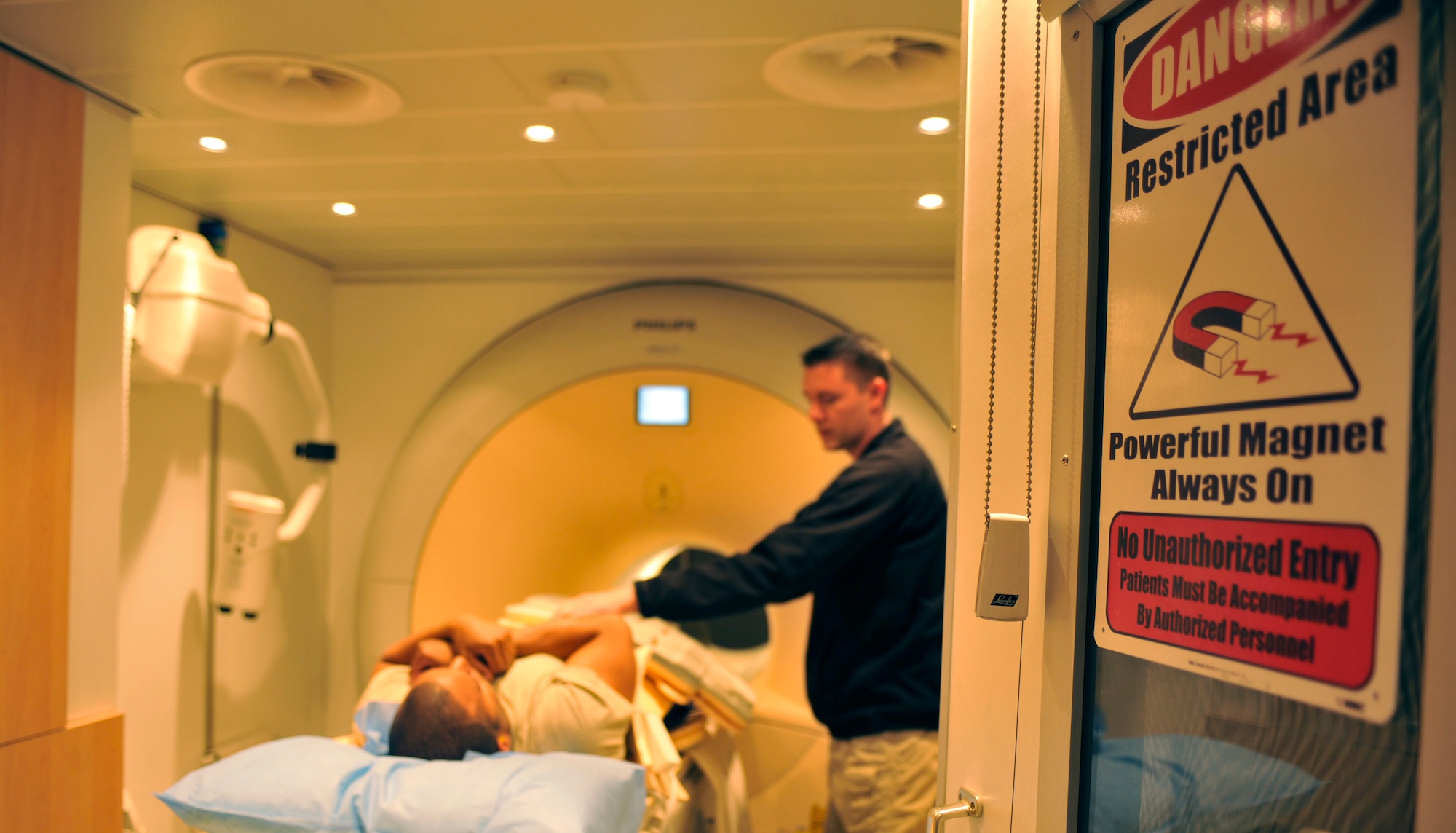 Cody Turner explains a part of the magnetic resonance imaging process to a patient at Bagram Airfield, Afghanistan, April 3, 2012. Turner is an MRI technician with the 455th Medical Support Squadron. The MRI machine consists of a powerful magnet that is rotated quickly to create a high-quality image of the body part being scanned. (U.S. Air Force photo/Airman 1st Class Ericka Engblom)