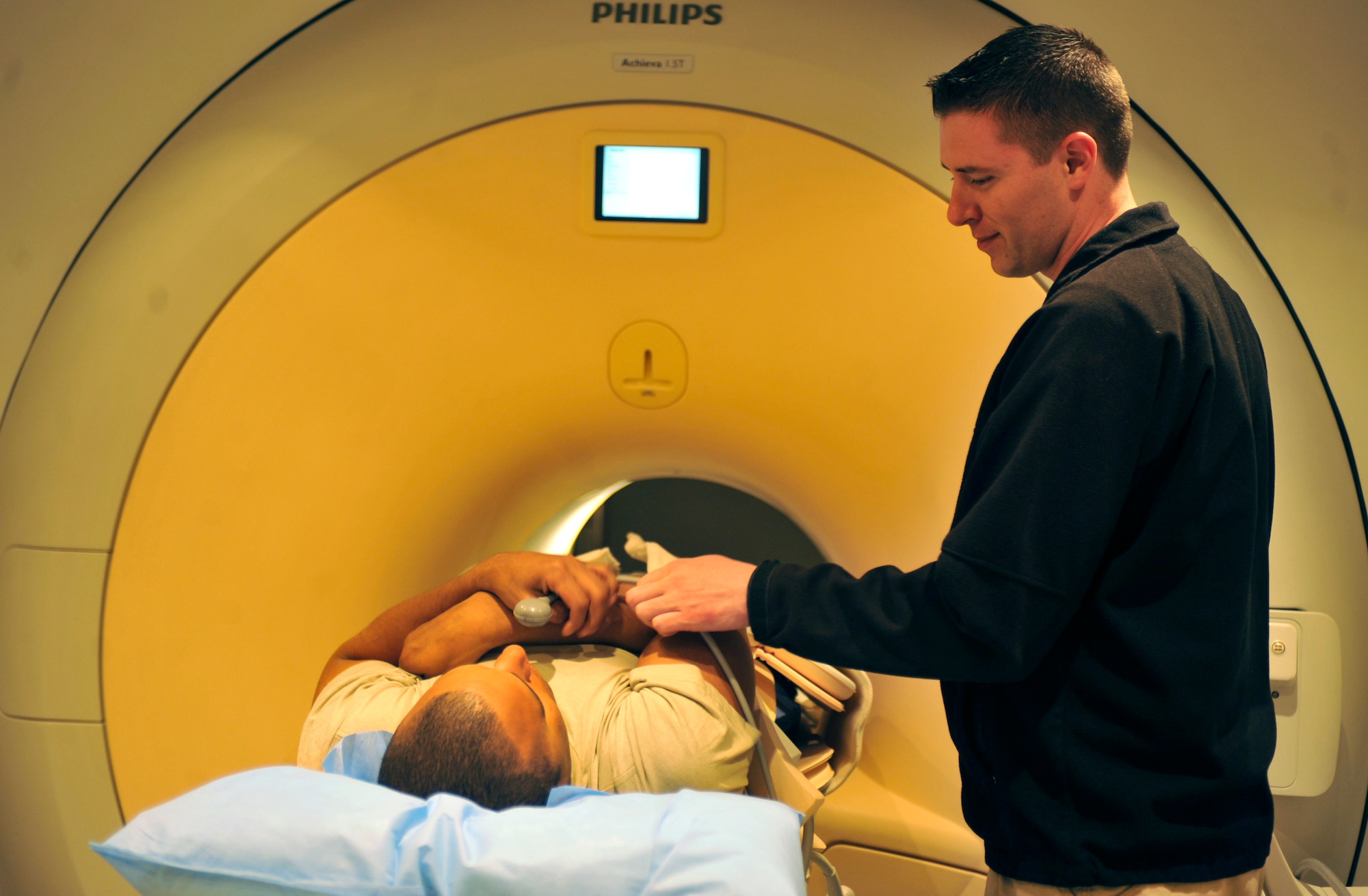 Cody Turner prepares a patient for his magnetic resonance imaging scan at Bagram Airfield, Afghanistan, April 3, 2012. Turner is an MRI technician with the 455th Medical Support Squadron and hails from Avon, Conn. The MRI machine allows medical personnel to procure a better image of certain body parts than an X-ray can provide. (U.S. Air Force photo/Airman 1st Class Ericka Engblom)