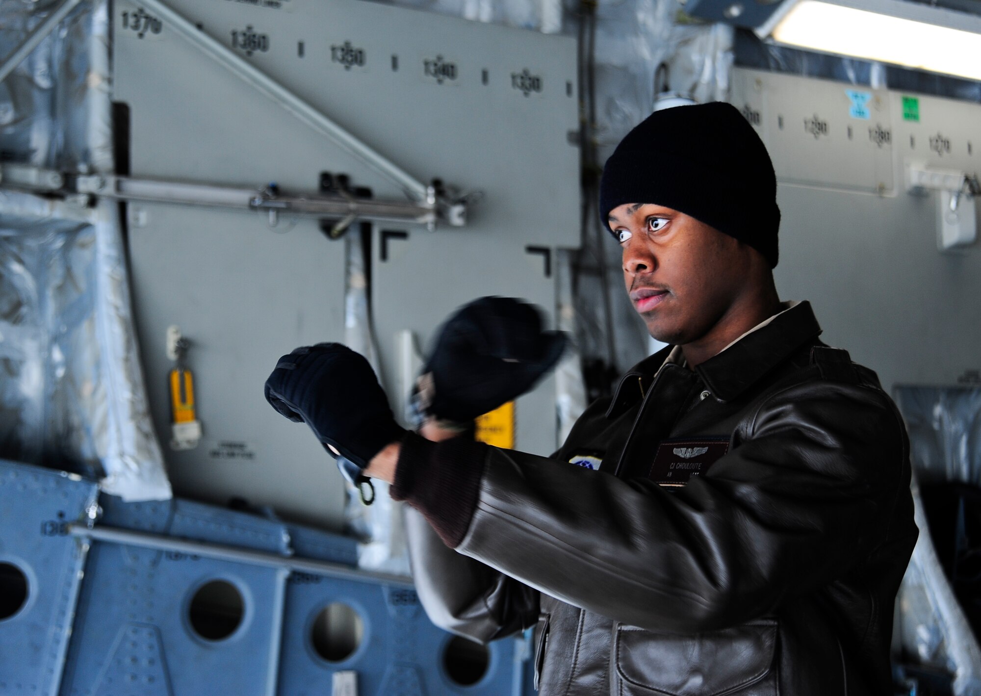 Airman Basic Carl-Henry Chouloute signals a cargo loader to stop March 20, 2012, while standing inside a C-17 Globemaster III at Bagram Airfield, Afghanistan. The C-17 Globemaster III can fit up to 158 passengers and five baggage pallets. Clouloute is an 817th Expeditionary Airlift Squadron Detachment 1 loadmaster deployed from Joint Base Lewis-McChord Wash. The 817th EAS Det. 1 is responsible for moving people and supplies between the Transit Center at Manas, Kyrgyzstan, and Afghanistan. (U.S. Air Force photo/Staff Sgt. Angela Ruiz)