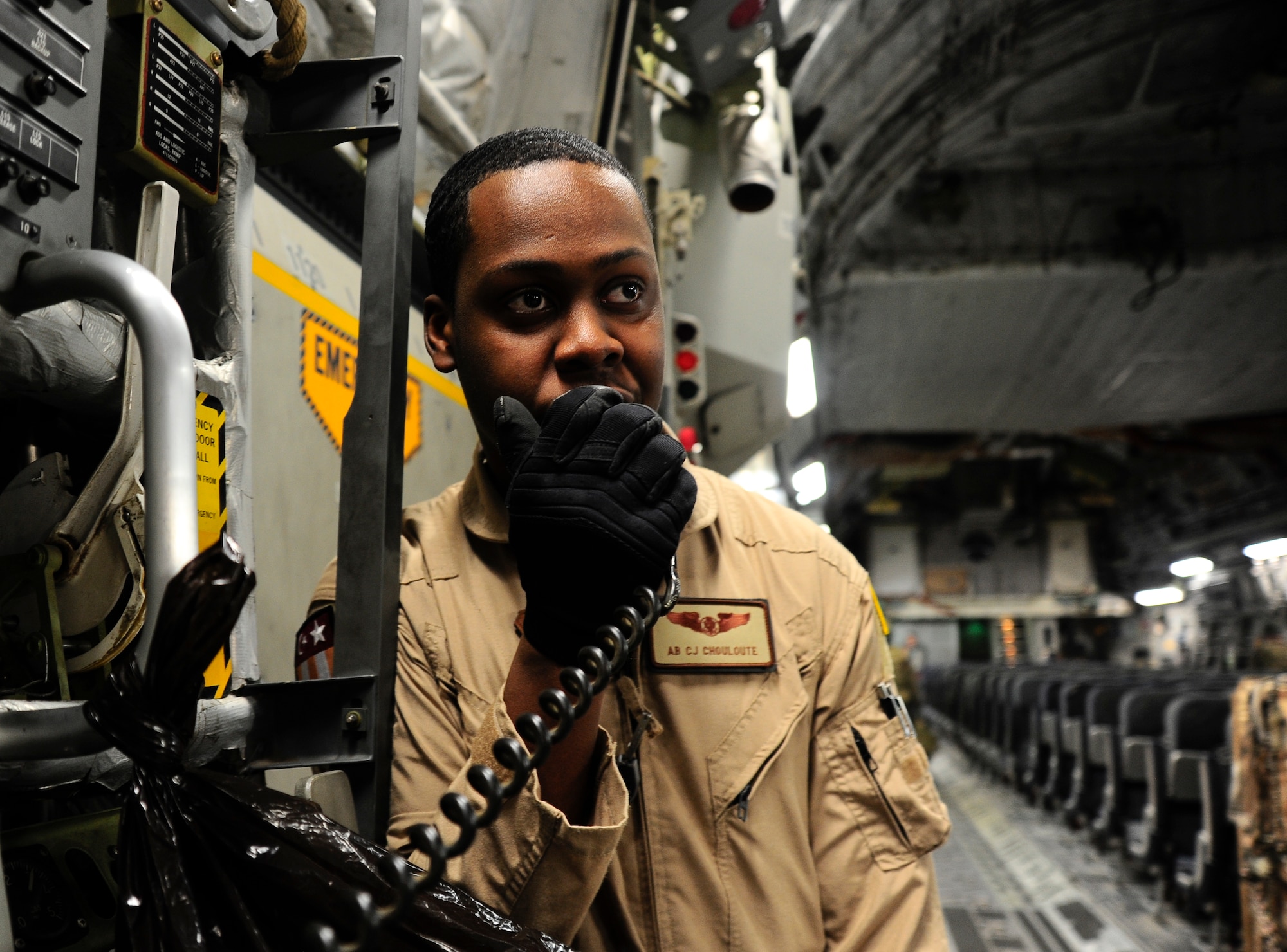 Airman Basic Carl-Henry Chouloute talks over the intercom on a C-17 Globemaster III March 20, 2012, at the Transit Center at Manas, Kyrgyzstan. Chouloute is an 817th Expeditionary Airlift Squadron Detachment 1 loadmaster deployed from Joint Base Lewis-McChord, Wash. (U.S. Air Force photo/Staff Sgt. Angela Ruiz)