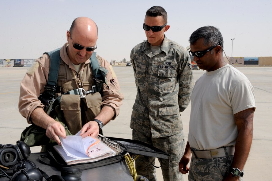 SOUTHWEST ASIA -- Col. Rodney Petithomme, 332nd Expeditionary Operations Group commander, reviews paperwork with Airman 1st Class Justin Glass, 332nd Expeditionary Aircraft Maintenance Squadron crew chief, and Master Sgt. Jesse Divelbess, 332nd Air Expeditionary Wing chaplain assistant, prior to take-off here, April 3, 2012. Divelbess shadowed Glass to learn how maintenance Airmen and pilots work together to launch aircraft. Petithomme is deployed from Osan Air Base, Korea, and is a native of Clovis, Calif. Glass is deployed from Shaw Air Force Base, S.C. and is a native of Tucson, Ariz. Divelbess is deployed with the Iowa Air National Guard, and is a native of Omaha, Neb. (U.S. Air Force photo by Staff Sgt. Joshua J. Garcia)