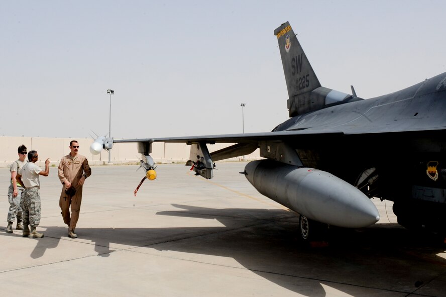 SOUTHWEST ASIA -- Maj. Joel Dopson, right, 332nd Air Expeditionary Wing plans and programs officer, briefs Master Sgt. Jesse Divelbess, 332nd AEW chaplain assistant, and Maj. Jillian Torango, 332nd AEW public affairs officer, on preflight procedures here, April 3, 2012. Members of the 332nd Wing Staff Agencies visited the flightline to learn about the maintenance and operations missions and how they exist with each other. Dopson is deployed from Eielson Air Force Base, Alaska, and is a native of Monroe, La. Divelbess is deployed from the Iowa Air National Guard, and is a native of Omaha, Neb. Torango is deployed from Joint Base Pearl Harbor-Hickam, Hawaii. (U.S. Air Force photo by Staff Sgt. Joshua J. Garcia)