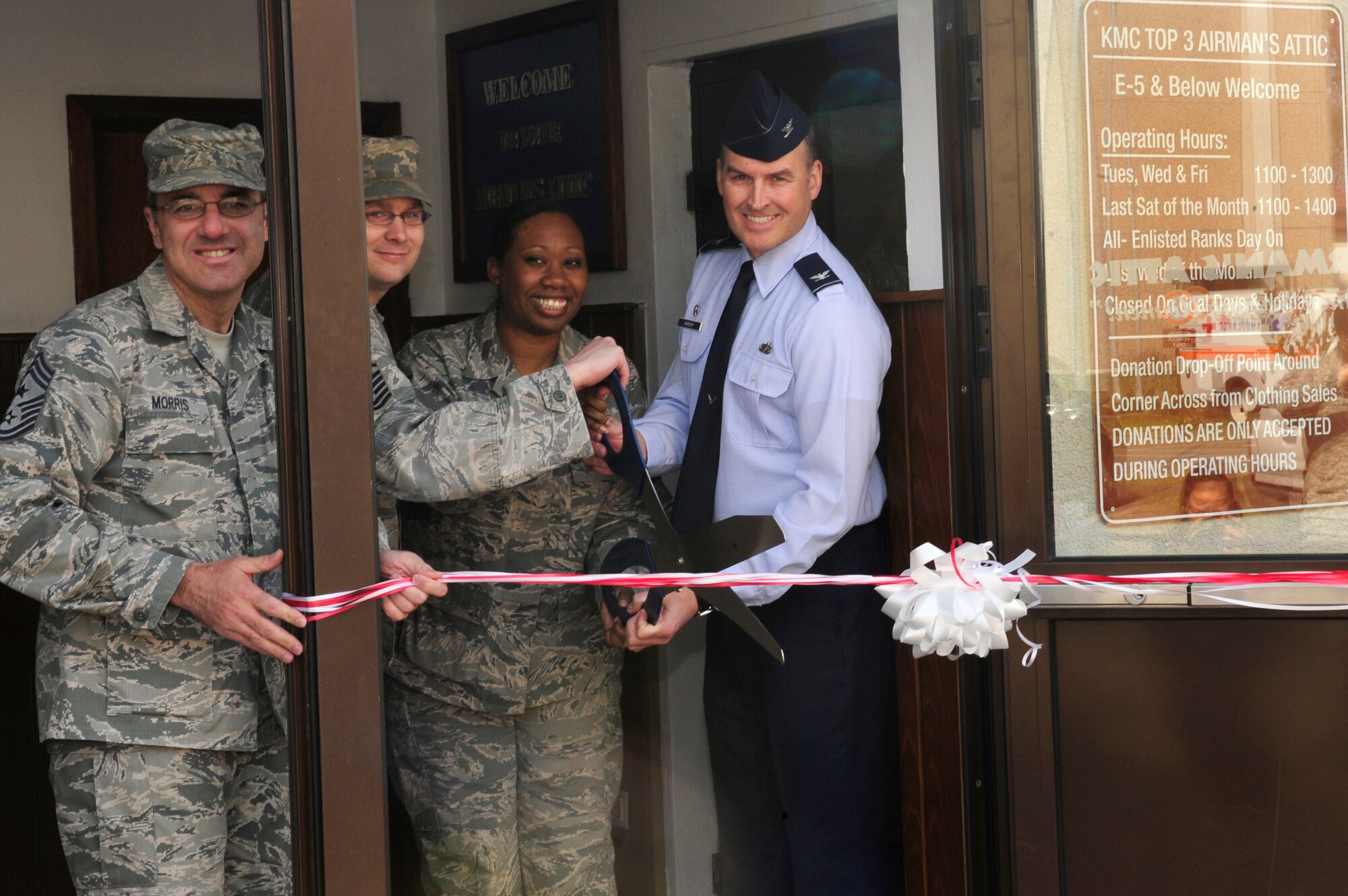 Chief Master Sgt. James Morris, 86th Airlift Wing command chief, and Col. Michael Monson, 86th Mission Support Group commander join other Airmen during a ribbon cutting ceremony for the new Airmen’s Attic, Ramstein Air Base, Germany, April 04, 2012. The Airman’s Attic is a function of the base where E-5’s and below can pick out donated items provided by members of the Ramstein community. The Airmen’s Attic new space has added an extra 2800 square feet to the original 700 square feet. (U.S. Air Force photo/ Senior Airman Aaron-Forrest Wainwright)