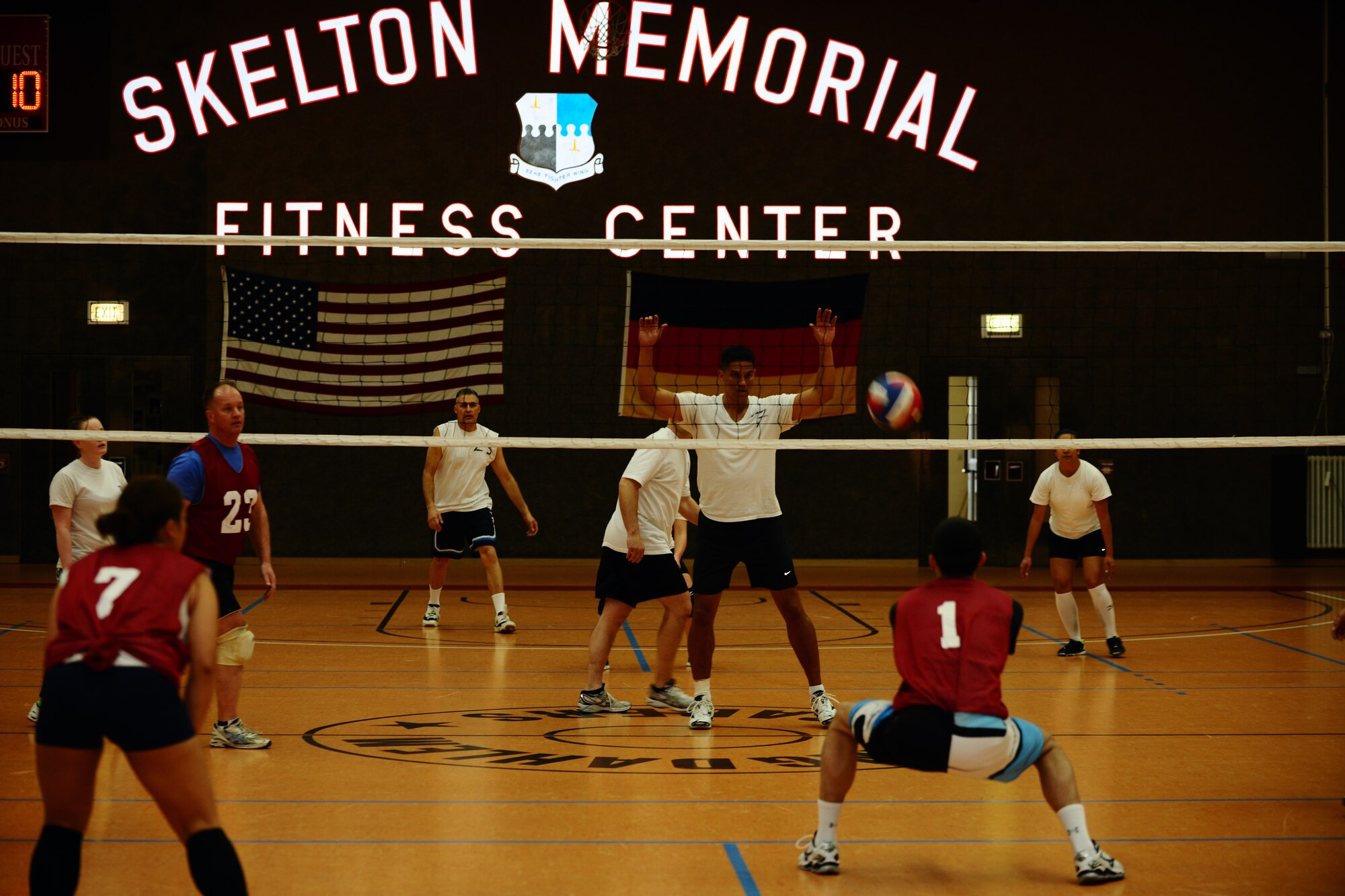 SPANGDAHLEM AIR BASE, Germany – Jared Rand, Spangdahlem American Forces Network, digs for a volleyball while members of the 606th Air Control Squadron team prepare to return the ball during the intramural volleyball championship game inside the Skelton Memorial Fitness Center here April 3. ACS defeated the 702nd Munitions Support Squadron 21-25, 25-19 and 15-8 in the final game of the double-elimination tournament. The tournament included nine teams comprised of Airmen and family members from different squadrons throughout Spangdahlem AB. (U.S. Air Force photo by Airman 1st Class Dillon Davis/Released)