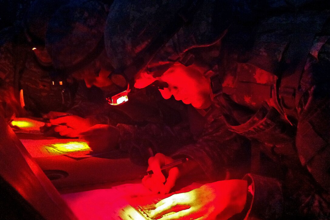 Indiana National Guard soldiers plot points on a map during the nighttime land navigation test during Indiana's Soldier and Noncommissioned Officer of the Year competition on Camp Atterbury, Ind., March 31, 2012.