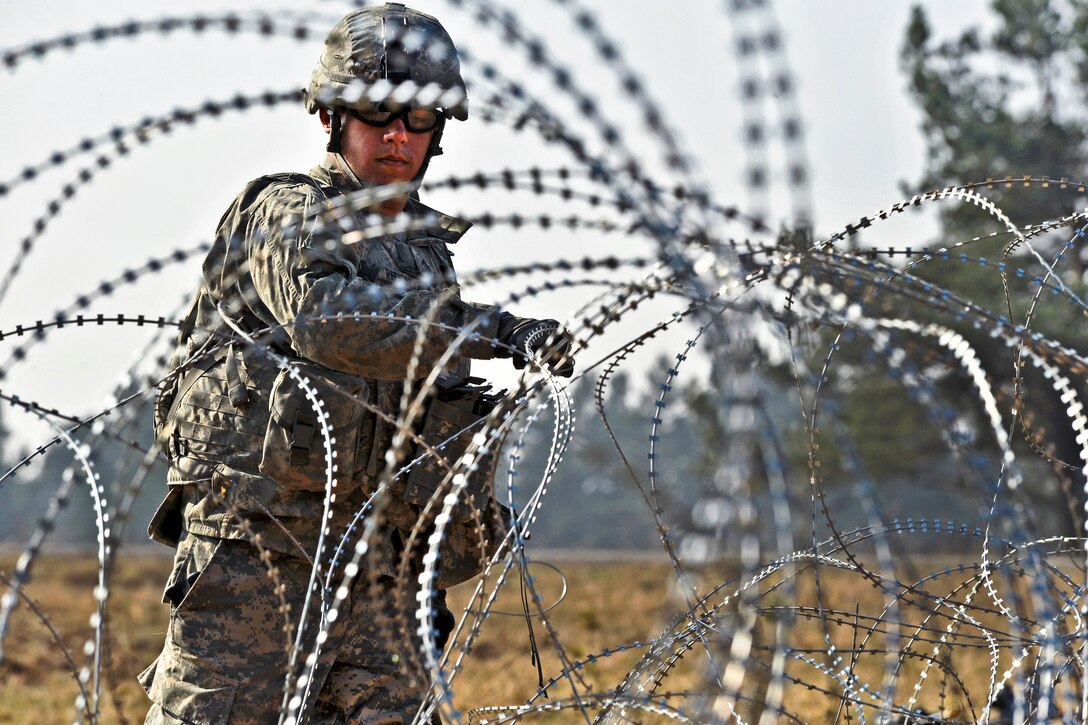 U.S. Army Pvt. Vincent Redondo lays out concertina wire during a situational training exercise at the Grafenwoehr Training Area, Joint Multinational Training Command in Vilseck, Germany, March 22, 2012. Redondo is assigned to Company I, 3rd Squadron, 2nd Cavalry Regiment. 