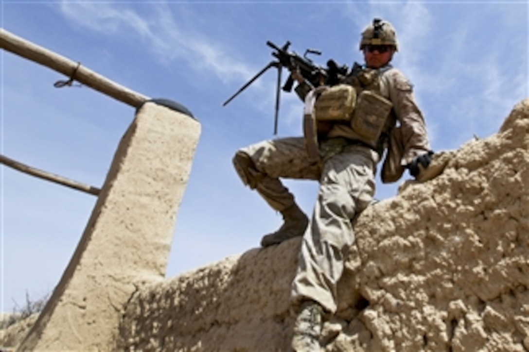 U.S. Marine Corps Lance Cpl. Sergey Huber clears a 7-foot tall wall during a regimental operation in Urmoz, Afghanistan, on March 25, 2012.  Huber is an automatic weapon gunner assigned to Alpha Company, 1st Battalion, 8th Marine Regiment.  