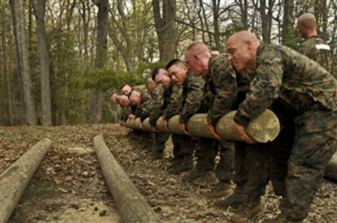 U.S. Marine Corps officer candidates with Charlie Company, Officer Candidate School, Marine Corps Base Quantico, Va., lift a 300-pound log during The Montford Point Challenge on March 24, 2012.  The challenge was a team building exercise meant to instill a sense of pride and camaraderie in the candidates.  