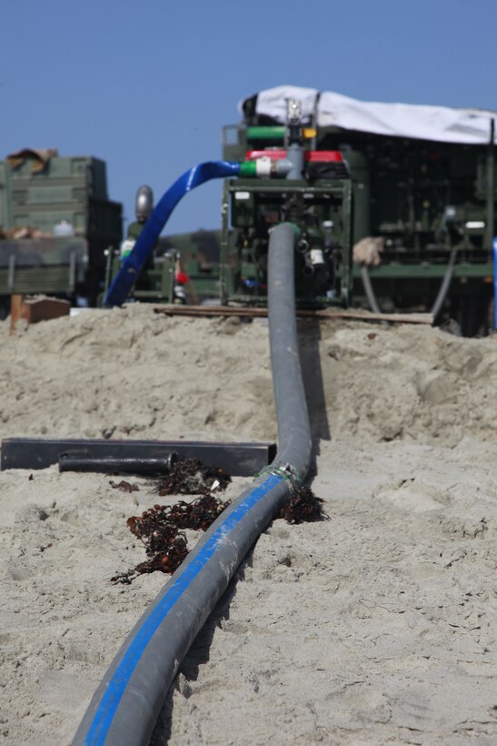 A hose carries water from the ocean into the diesel powered water pump, which can pump water at a rate of 150 gallons per minute before being filtered by the Tactical Water Purification System. The TWPS is an integral part of Marine Expeditionary Unit Exercise, held here, April 2-12. During the exercise, the 15th MEU is using roughly 1,000 gallons a day for drinking and cooking. Using the TWPS, the daily requirement was produced in just about one hour.