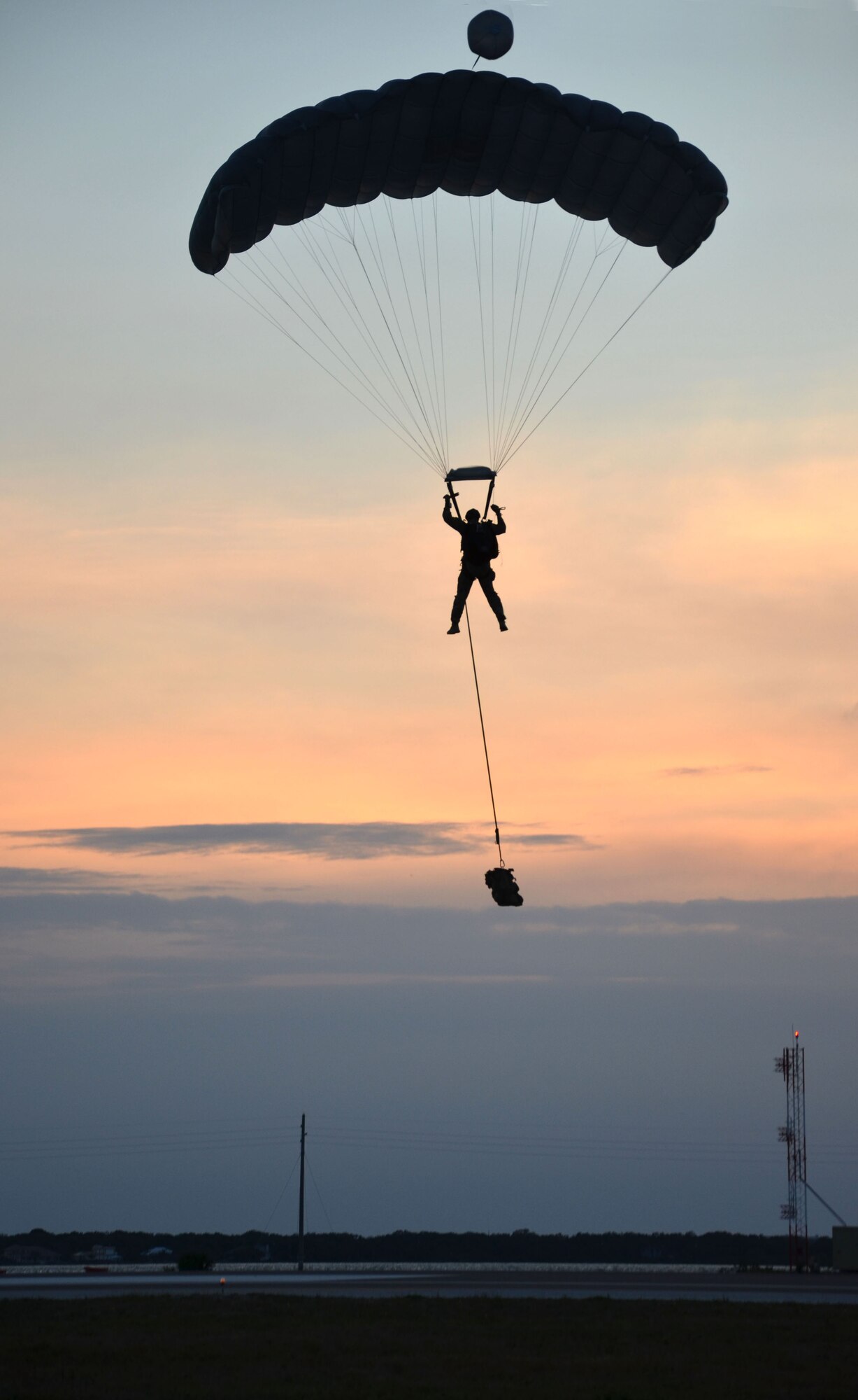 An Air Force Reserve pararescueman, carrying an additional bag of supplies attached to his harness, guides his way in for a landing after a free-fall jump here April 5. Airmen of the 920th Rescue Wing, Patrick Air Force Base, Fla., train extensively to keep current on their combat search and rescue qualifications. This includes parachuting during daylight and dusk. Pararescuemen are highly trained in parachuting, mountaineering and SCUBA and are among the most highly trained emergency trauma specialists in the U.S. military. With this medical and rescue expertise, PJs are able to perform life-saving missions in the world?s most remote areas. (U.S. Air Force photo/2nd Lt. Leslie Forshaw)