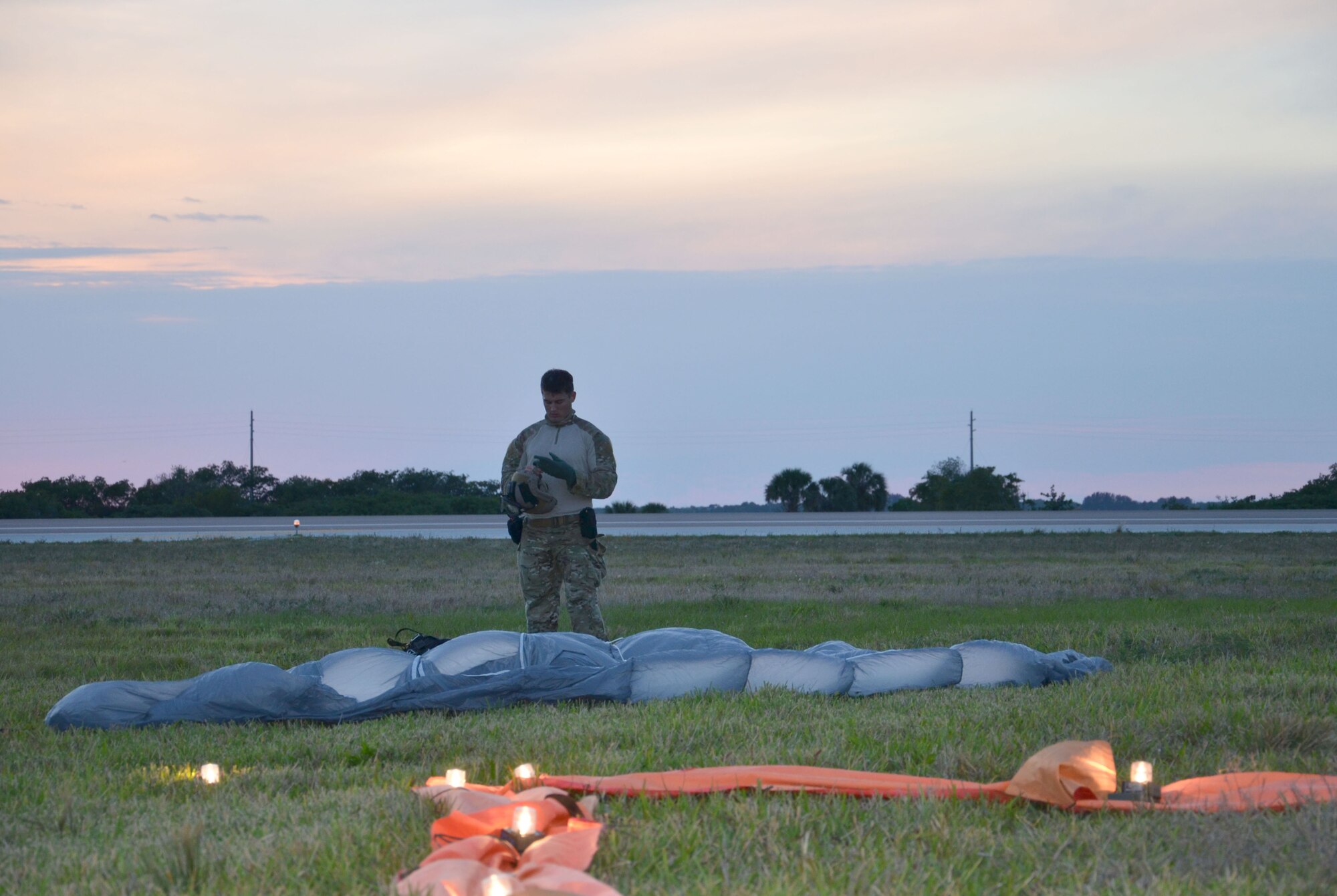 Staff Sgt. Andrew West, Air Force Reserve pararescueman, takes off his gear after a free-fall jump here April 5. Airmen of the 920th Rescue Wing, Patrick Air Force Base, Fla., train extensively to keep current on their combat search and rescue qualifications. This includes parachuting during daylight and dusk. Pararescuemen are highly trained in parachuting, mountaineering and SCUBA and are among the most highly trained emergency trauma specialists in the U.S. military. With this medical and rescue expertise, PJs are able to perform life-saving missions in the world?s most remote areas. (U.S. Air Force photo/2nd Lt. Leslie Forshaw)