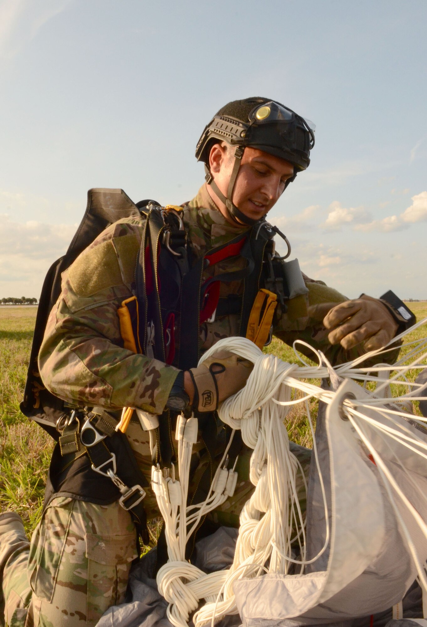 Staff Sgt. Brandon Forshaw, Air Force Reserve pararescueman, ties his parachute cords together after landing from a free-fall jump here April 5. Airmen of the 920th Rescue Wing, Patrick Air Force Base, Fla., train extensively to keep current on their combat search and rescue qualifications. This includes parachuting during daylight and dusk. Pararescuemen are highly trained in parachuting, mountaineering and SCUBA and are among the most highly trained emergency trauma specialists in the U.S. military. With this medical and rescue expertise, PJs are able to perform life-saving missions in the world?s most remote areas. (U.S. Air Force photo/2nd Lt. Leslie Forshaw)