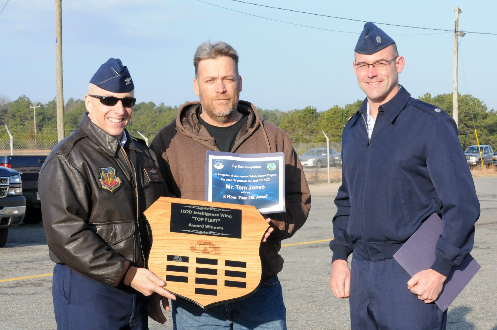 Col. Anthony Schiavi, 102nd Intelligence Wing commander, and Lt. Col. Stephen Demianczyk, 102nd Civil Engineer Squadron commander, present the first "Top Fleet" award to vehicle control officer Allen Thompson at a ceremony on Otis Air National Guard Base, Mass., March 26. This is the first time the award has been granted since the "Top Fleet" program was established earlier this year. (National Guard photo by Tech. Sgt. Kerri Cole/Released)