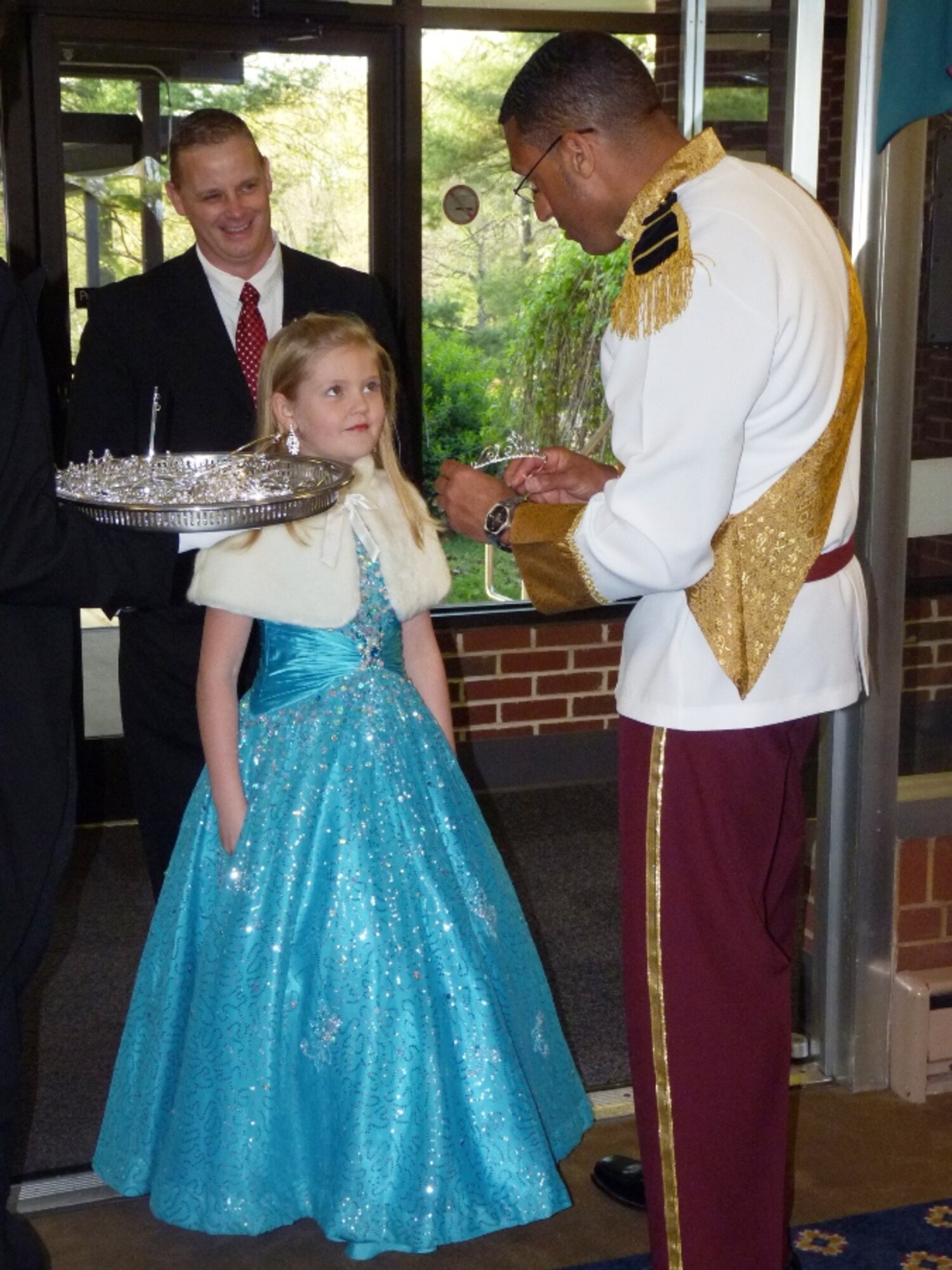 Portraying the role of ‘Prince Charming,’ George DeShields, AEDC assistant fire chief, adorned one of the many princesses that attended the Daddy-Daughter Dance March 23 with a tiara. (Photo provided)