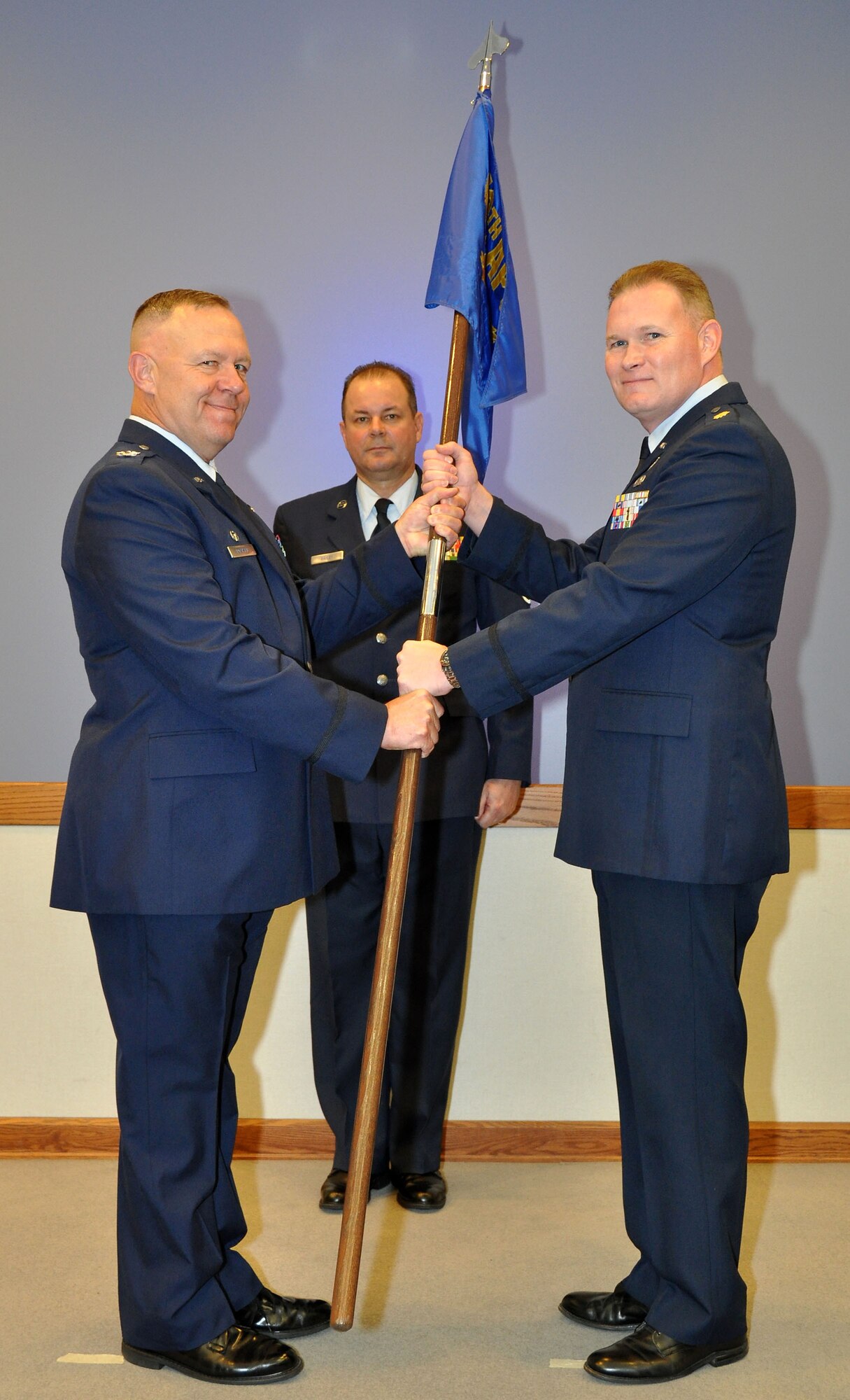 Colonel Elwin Rozyskie, Jr., Commander of the 482nd Mission Support Group hands Major David C. Lionberger IV the 70th Aerial Port Squadron guidon at the unit’s Assumption of Command Ceremony. The presenting of the units guidon to a new commander symbolizes the bestowing of responsibility of command. (U. S. Air Force Photo/Senior Airman Jacob Jimenez, 482nd Fighter Wing Public Affairs).